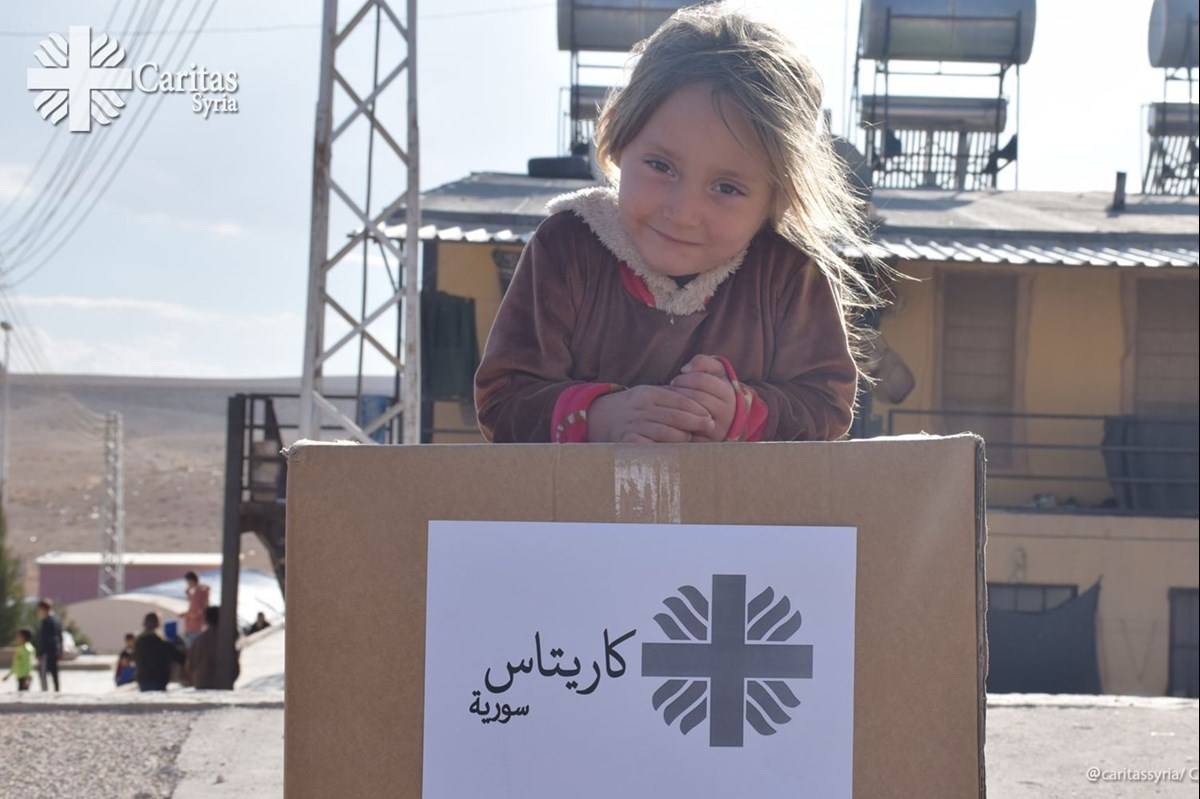 Mädchen mit Hilfsgütern der Caritas (Foto: Caritas Syria / Communication Department)