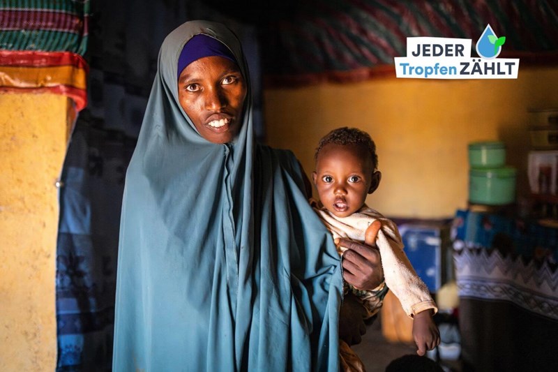 Tuku Demphe Gabale hält das Jüngste ihrer vier Kinder im Arm. Mit der Schwangerschaft wurde bei ihr auch eine Unterernährung festgestellt. Seither kämpft sie mit Nahrungsmittellieferungen von unserem Partner PACIDA für ihre Gesundheit - und die ihres Kindes.