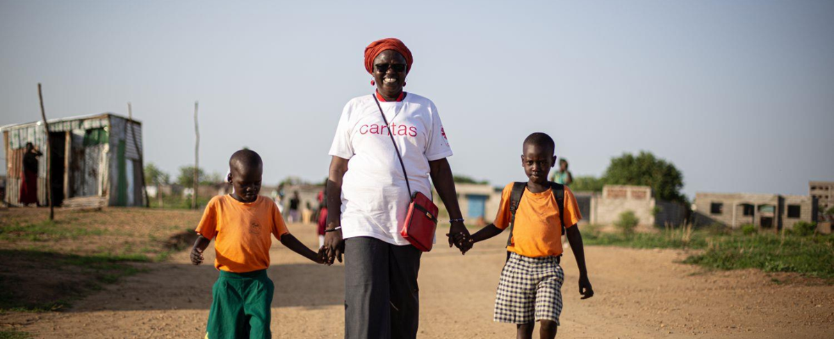 Betty Loro, die Leiterin des Kinderzentrums St. Claire, läuft mit zwei Kindern an der Hand durch Juba. (Foto: Philipp Spalek / Caritas international)